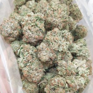 Sticky Pink Kush cannabis buds glistening with trichomes, exuding a strong gassy aroma and vibrant pink and green hues.